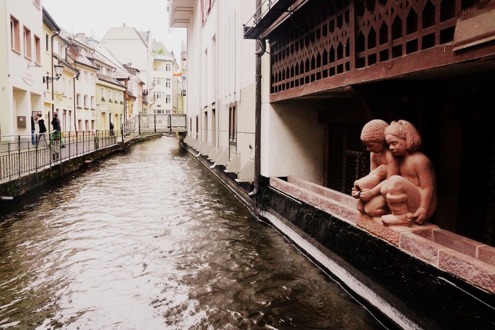 Views along the Bachle small canals running along street edges in Freiburg, Germany