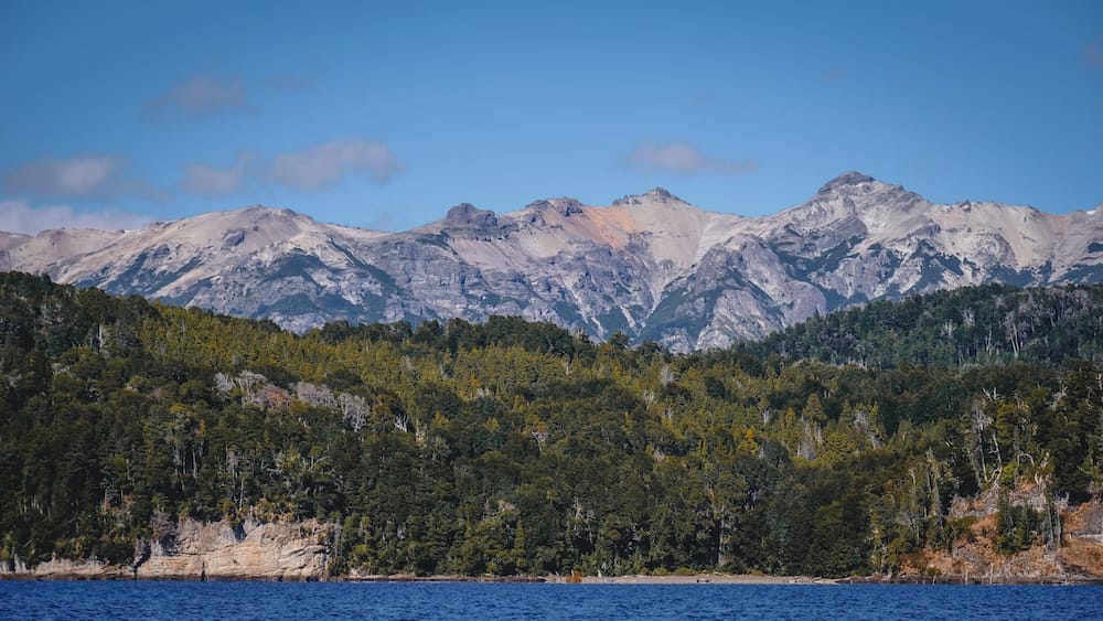 Villa La Angostura Patagonia UV exposure clear skies mountain landscape Argentina high latitude sun Villa La Angostura Patagonia mountain landscape under clear blue skies with forest and lake environment where high latitude and thin atmosphere create intense UV radiation despite cool temperatures