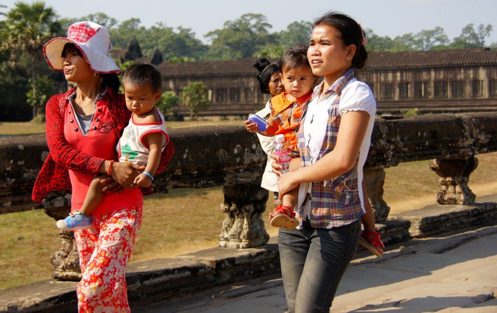 Visiting the temples of Angkor is a family affair with women carrying their children in Cambodia 