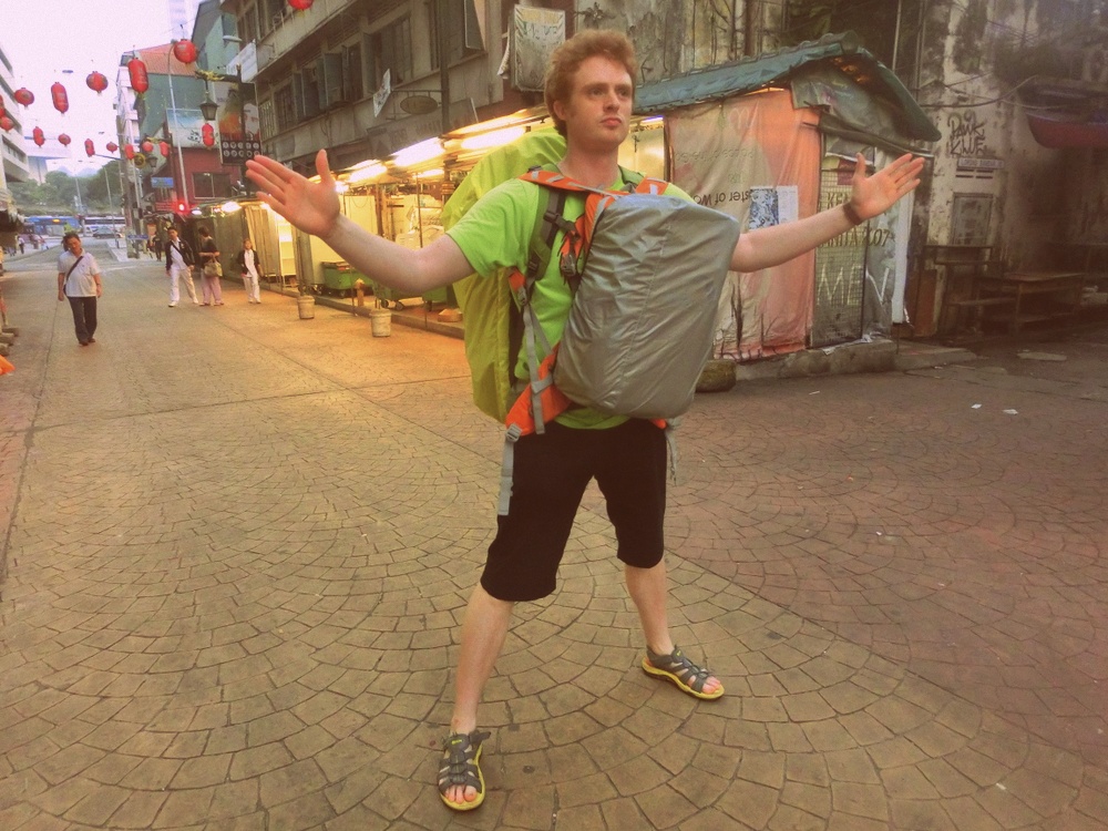 Nomadic Samuel walking through Chinatown in KL, Malaysia wearing both my day pack and my backpack 
