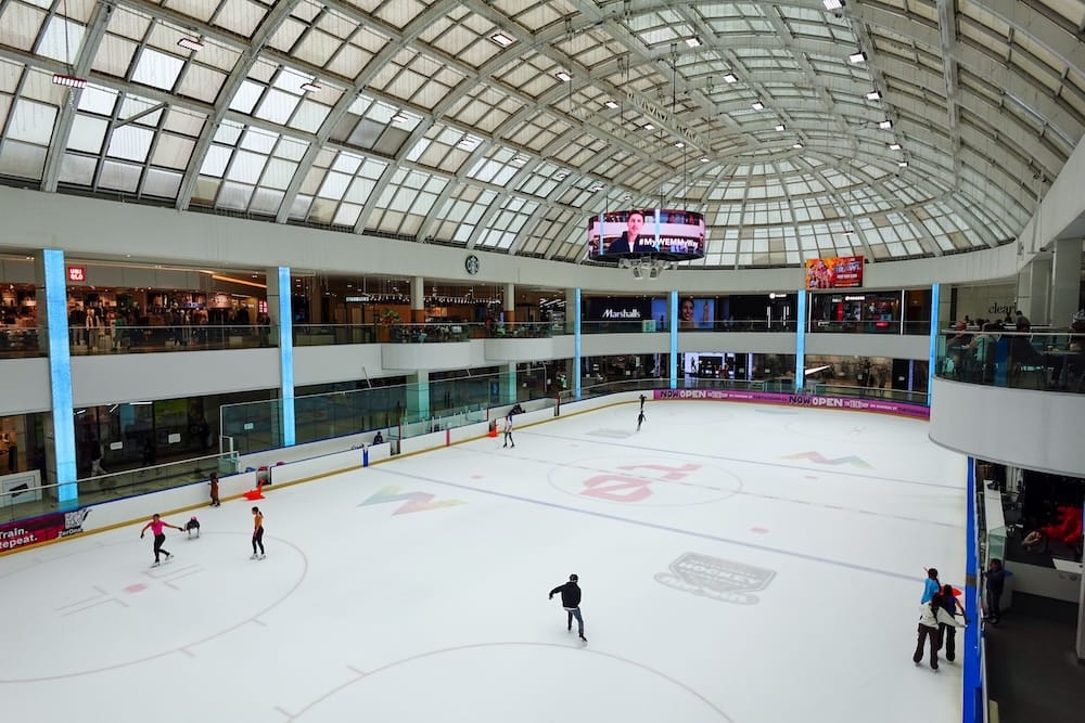 Pista de hielo interior de West Edmonton Mall, Edmonton, Alberta, Canadá Varias personas patinan sobre la pista de hielo interior de West Edmonton Mall, en Edmonton, Alberta, Canadá, bajo un techo vidriado abovedado y rodeadas por varios niveles de comercios y balcones.
