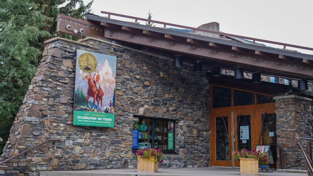 Whyte Museum of the Canadian Rockies exterior entrance, Banff, Alberta, Canada Stone and timber exterior entrance of the Whyte Museum of the Canadian Rockies in Banff, Alberta, Canada, with a banner promoting a past "Trail Riders of the Canadian Rockies" centennial exhibition and flower planters by the door.