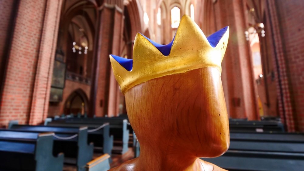 Wooden face sculpture with crown at the Basilica of St. Nikolai in Luneburg, Germany 