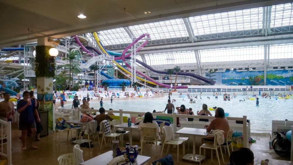 World Waterpark Wave Pool and Water Slides at West Edmonton Mall Wave pool, colourful water slides and indoor seating inside World Waterpark at West Edmonton Mall in Edmonton, Alberta, with swimmers and families enjoying the attraction.