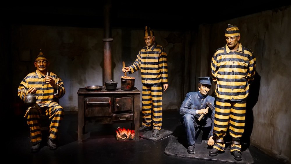 Yellow and black stripe prisoner outfits of statues and sculptures on display at the notorious Prison at the End of the World penal colony in Ushuaia, Argentina 